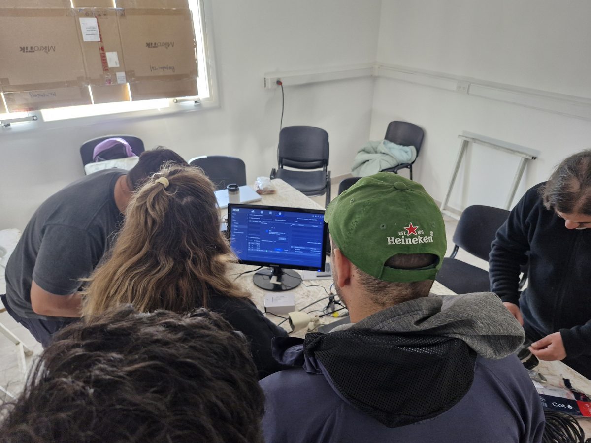 Grupo de cursantes revisando la configuración de un NVR en clase