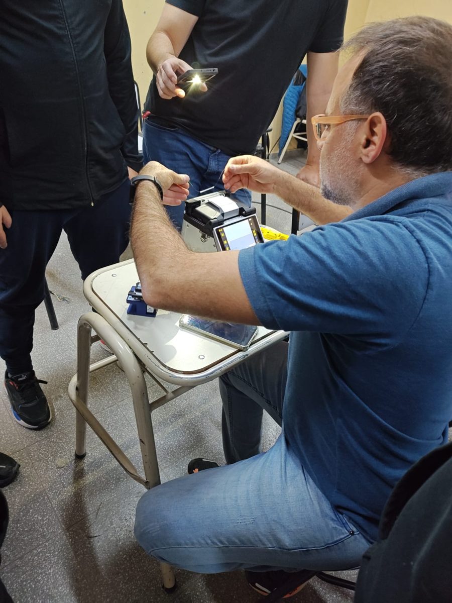 Instructor mostrando el manejo de la fusionadora de fibra óptica