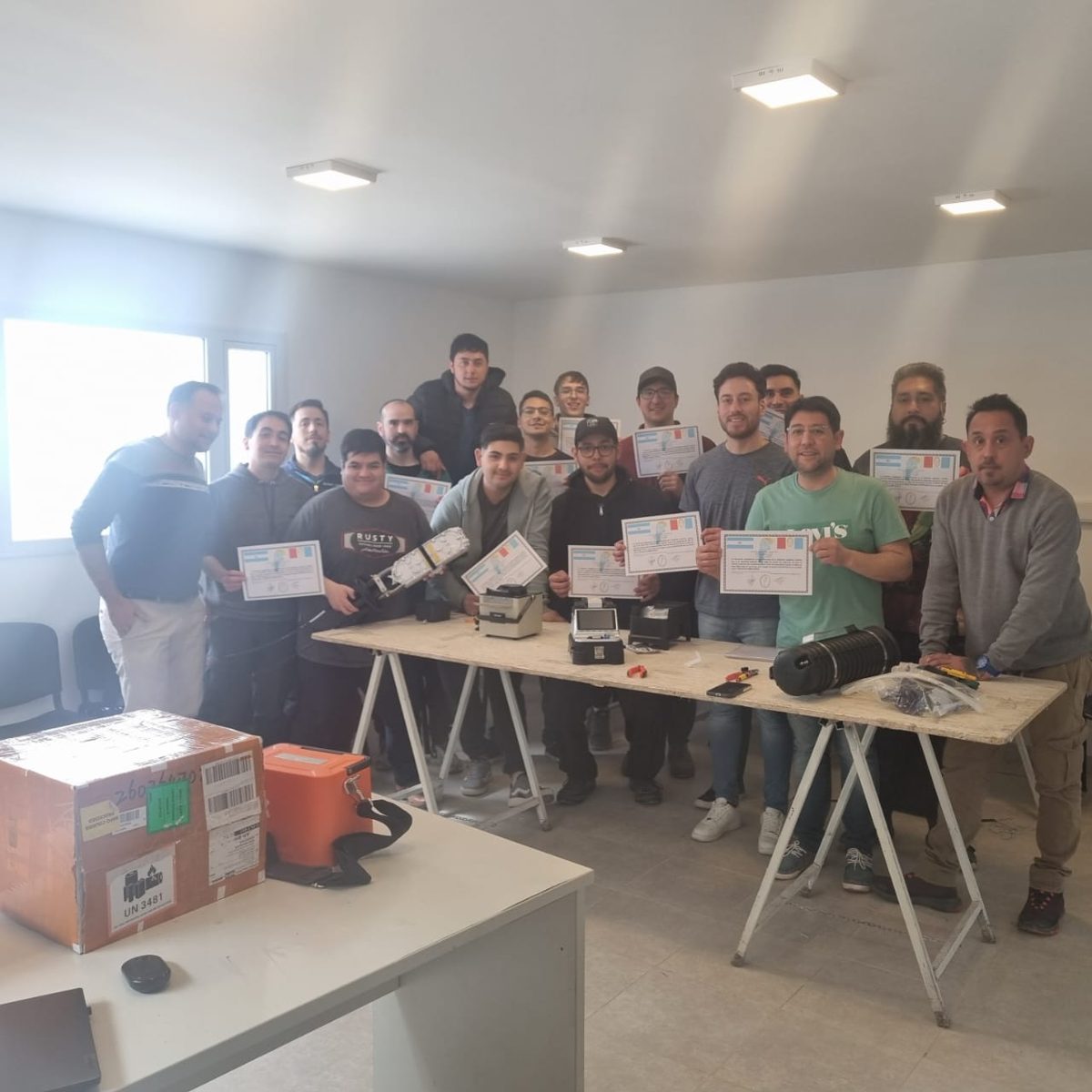 Grupo de egresados con sus certificados del curso de fibra óptica